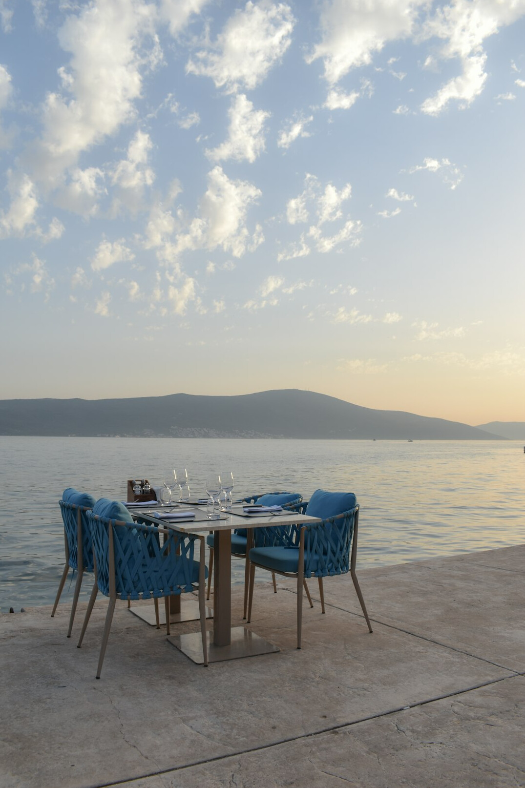 Outdoor dining terrace set for a sunset dinner overlooking the coast