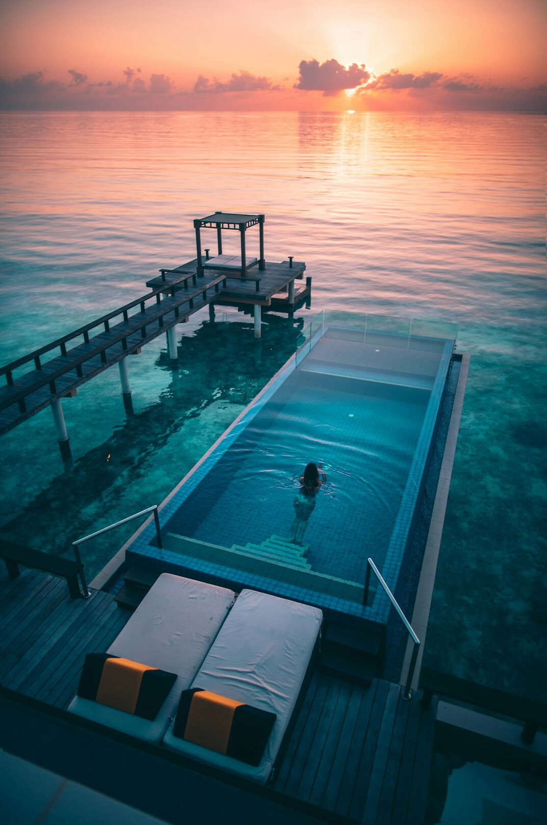 Infinity swimming pool overlooking the ocean at sunset